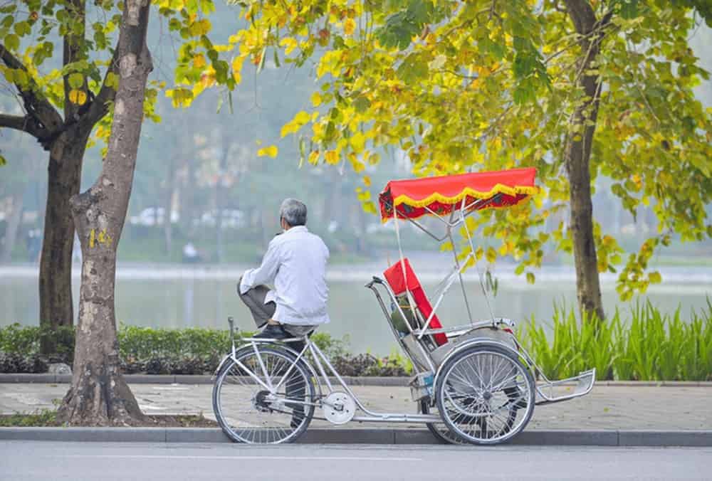 Pedicabs carrying tourists around Hanoi's Old Quarter are parked near Hoan Kiem Lake.