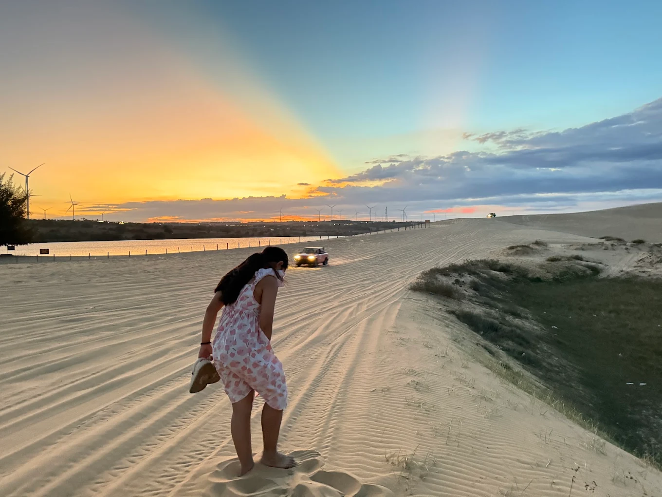 Bau Trang White Sand Dunes at sunrise with golden sand and a colorful sky, Mui Ne, Vietnam.