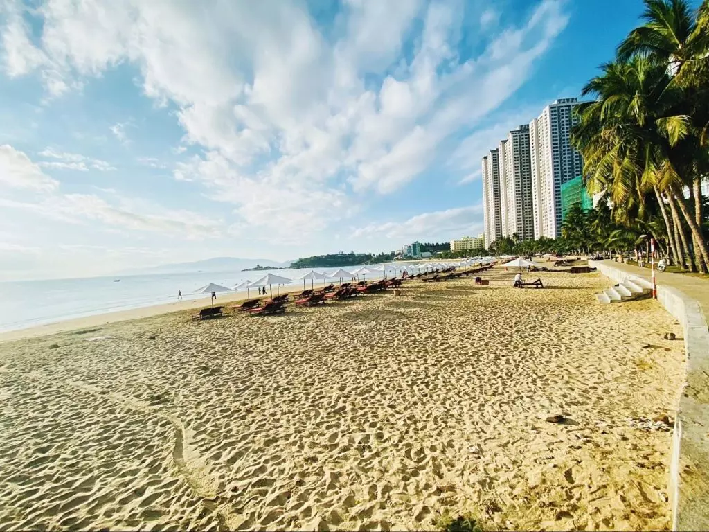 Beautiful Nha Trang beach during peak sunny season with tourists enjoying the sea.