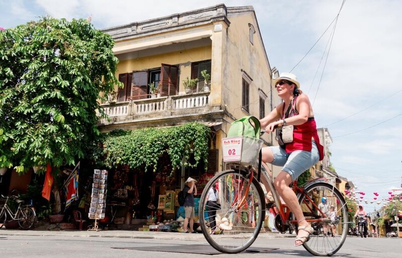 Bicycling through Hoi An’s ancient streets, surrounded by old yellow walls and historic buildings.