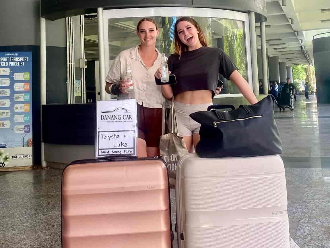 Driver holding a welcome sign at Da Nang Airport arrival gate for airport transfer service