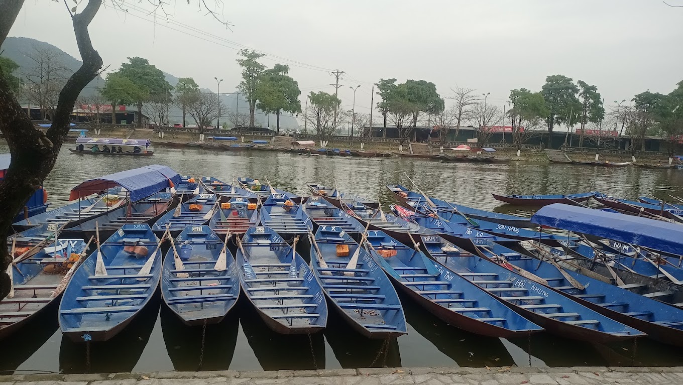 Scenic view of Ben Duc (Duc Wharf) at the Perfume Pagoda, featuring boats ready to take visitors along the tranquil waters.