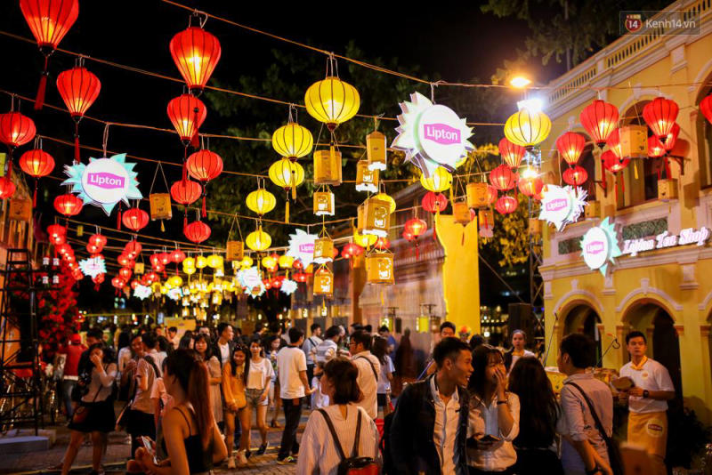 Lantern-lit streets of Hoi An with locals enjoying food and the lively atmosphere at night.