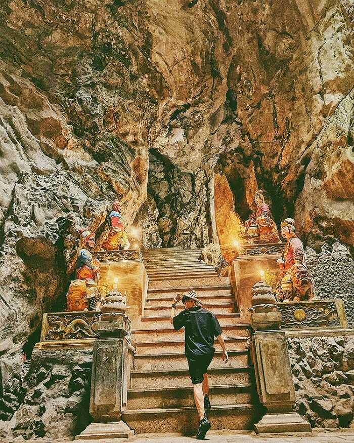 Inside Huyen Khong Cave at Marble Mountains with sunlight illuminating the cave.