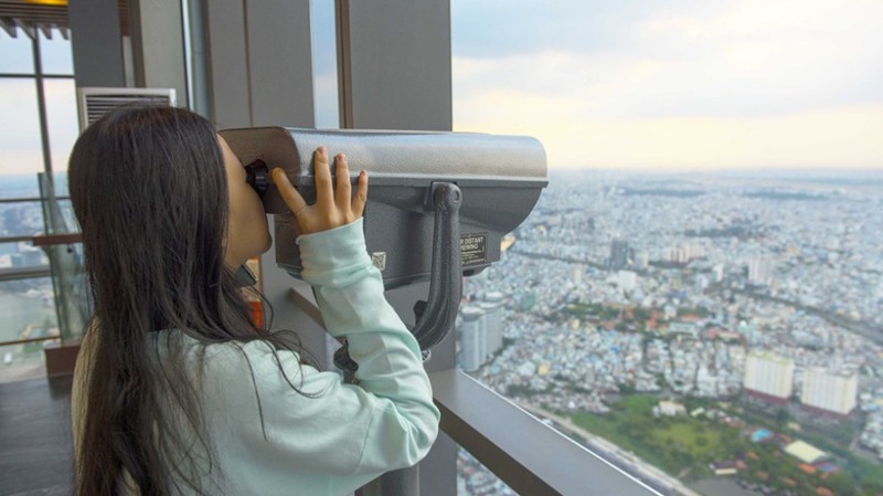 Night view of Ho Chi Minh City from Landmark 81 Skyview Observatory with city lights and binoculars.