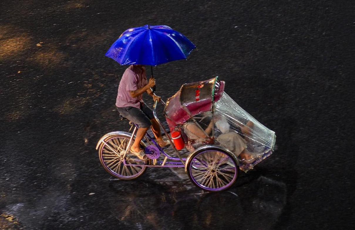 Essential items for traveling to Hue during the rainy season, including an umbrella, raincoat, and warm clothes.