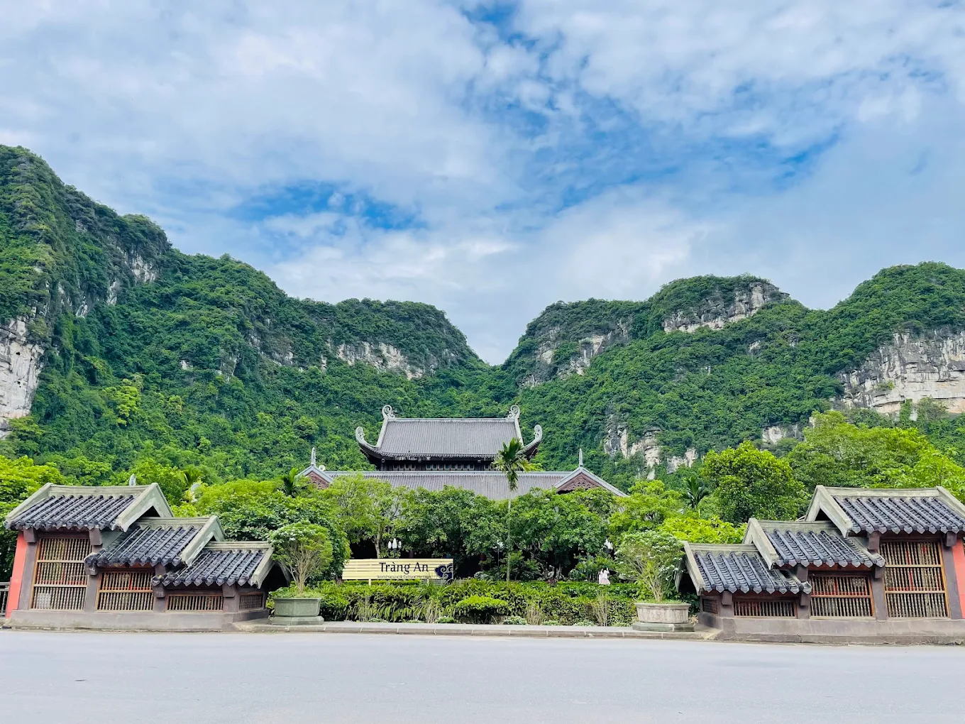 Trang An Ninh Binh scenic landscape with limestone mountains, rivers, and tourist boats.