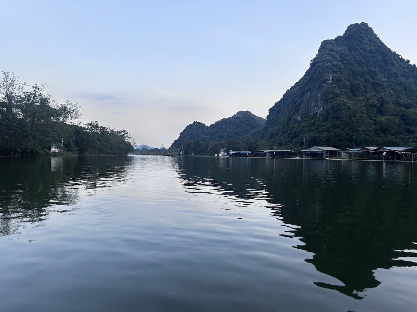 Tranquil view of Yen Stream at the Perfume Pagoda, showcasing lush greenery and traditional boats along the water.